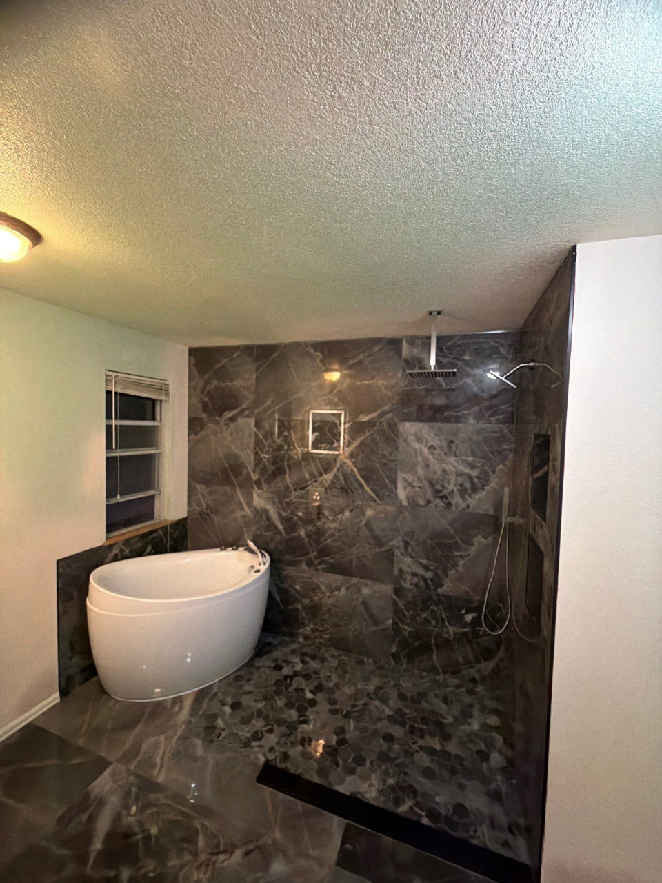 Finished bathroom remodel with dark tile shower and freestanding tub Denver Aurora CO